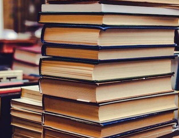A tall stack of hardcover books